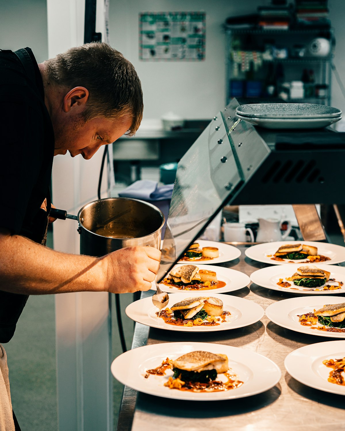 Chef plating dishes on the line in a commercial restaurant kitchen in Los Angeles